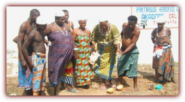 Mama Zogbe(center)  and Mama Zodede (observing on left)  pouring libations.
