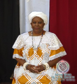 Mama Zogbe, wearing teal and custom spiritual regalia.